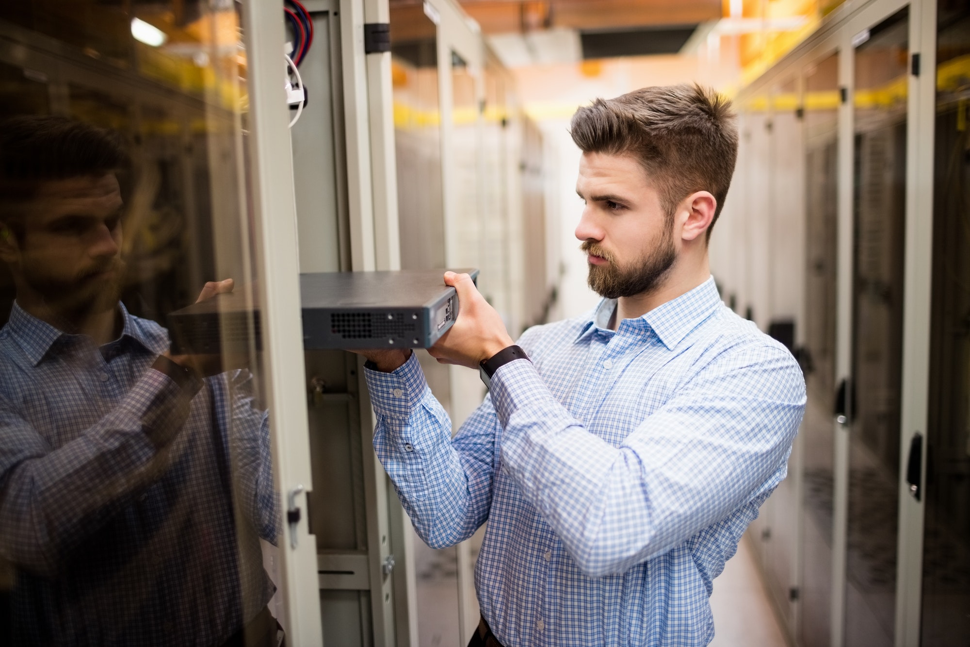 Technician removing a dedicated server from rack mounted server