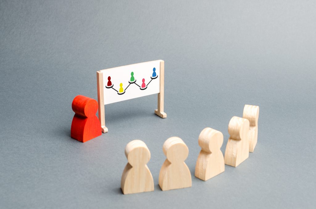 Employees stand in a row at an employee training meeting.